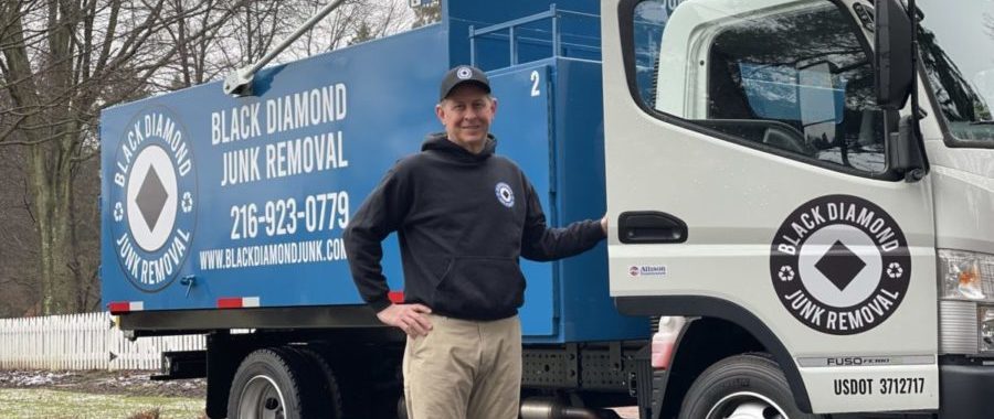 black diamond junk removal pro smiling in front of junk removal truck