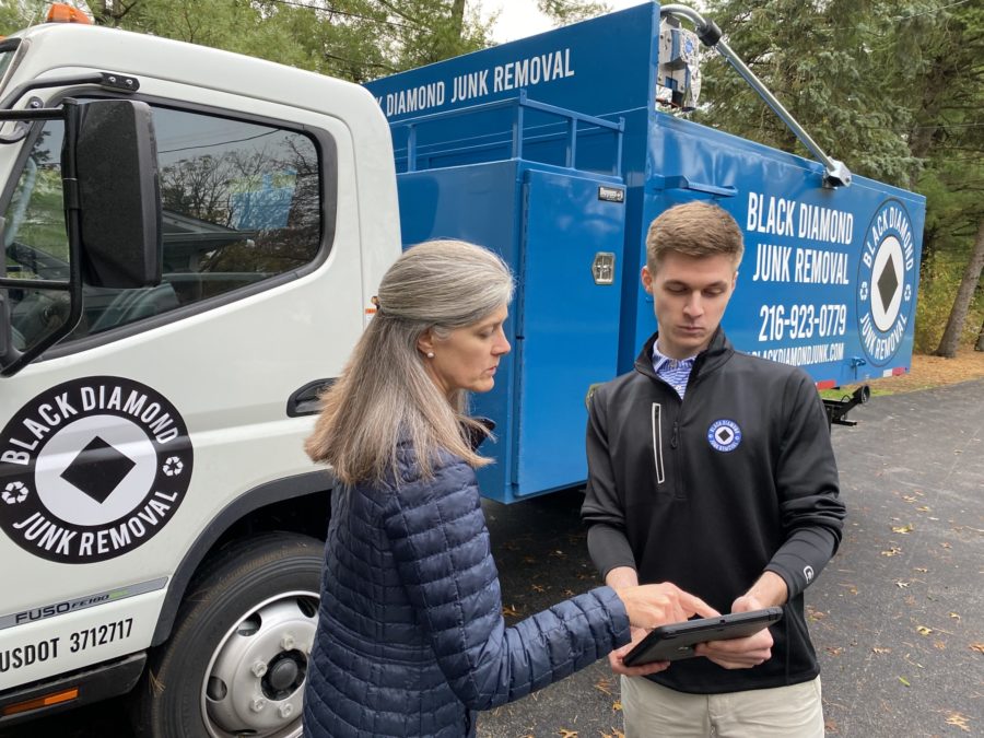 two people agreeing on a quote for junk removal in front of a junk removal truck